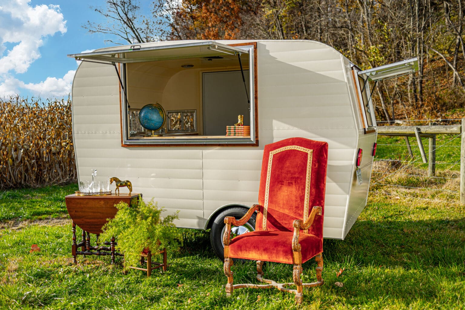 White food service trailer with vintage furniture decorating the outside